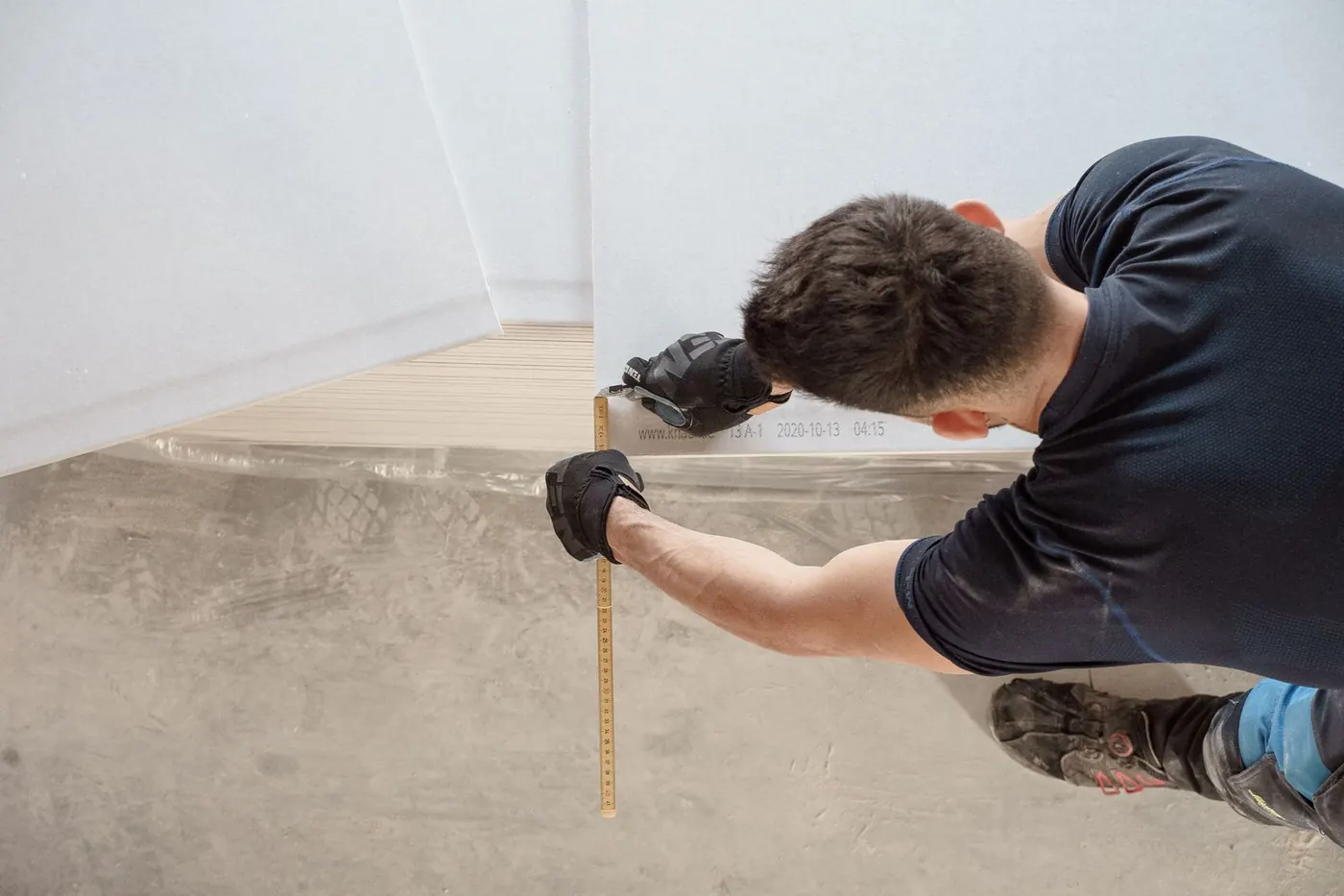 Worker measuring and cutting flooring panels on a renovation site