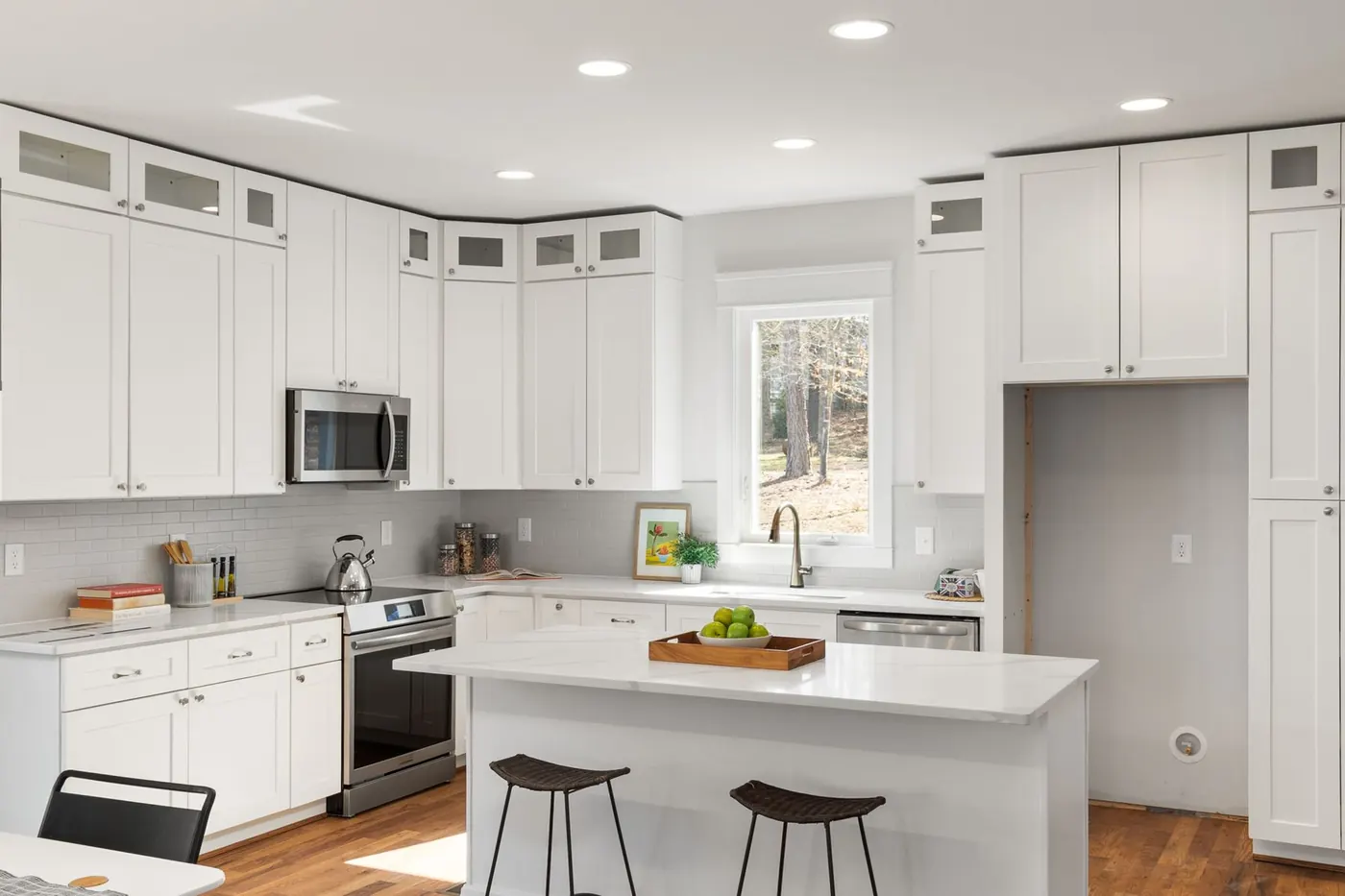 White shaker-style kitchen with an island and bar stools